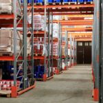 Industrial warehouse interior with organized shelves stacked with packages and goods.